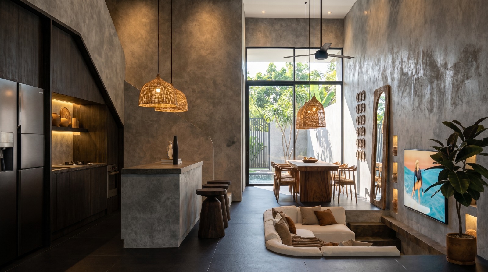Double-height living space with kitchen island, sunken sofa and dining beyond