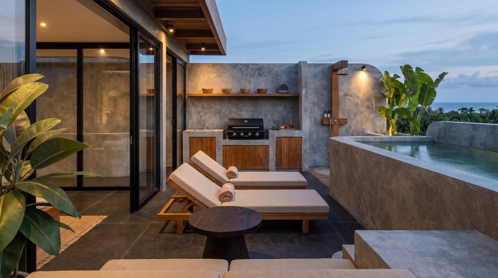 Rooftop sun deck with loungers, outdoor shower and pool facing the ocean