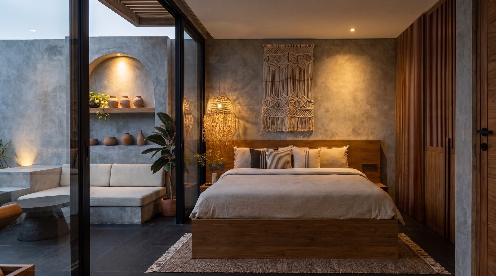 Rooftop bedroom with teak headboard, macramé wall hanging and sliding doors to the terrace banquette